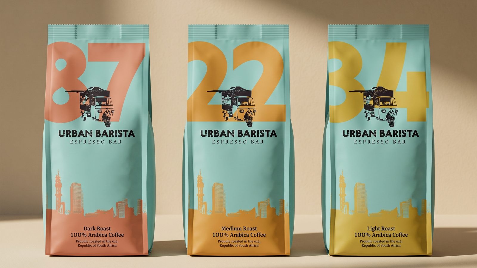 Three Urban Barista coffee bags in duck-egg teal, numbered 87, 22 and 34 in coral, ochre and mustard.